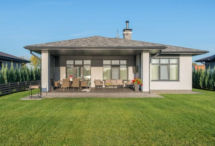 Example photo: Single-story house with a covered patio facing a large flat lawn