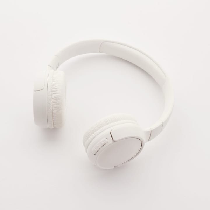 Example photo: White wireless headphones on a plain white surface in flat light