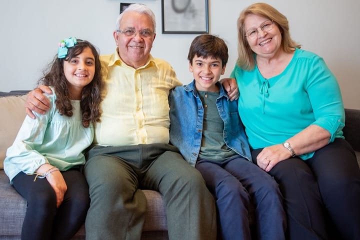 Example photo: Grandparents and two grandkids smiling together on a sofa